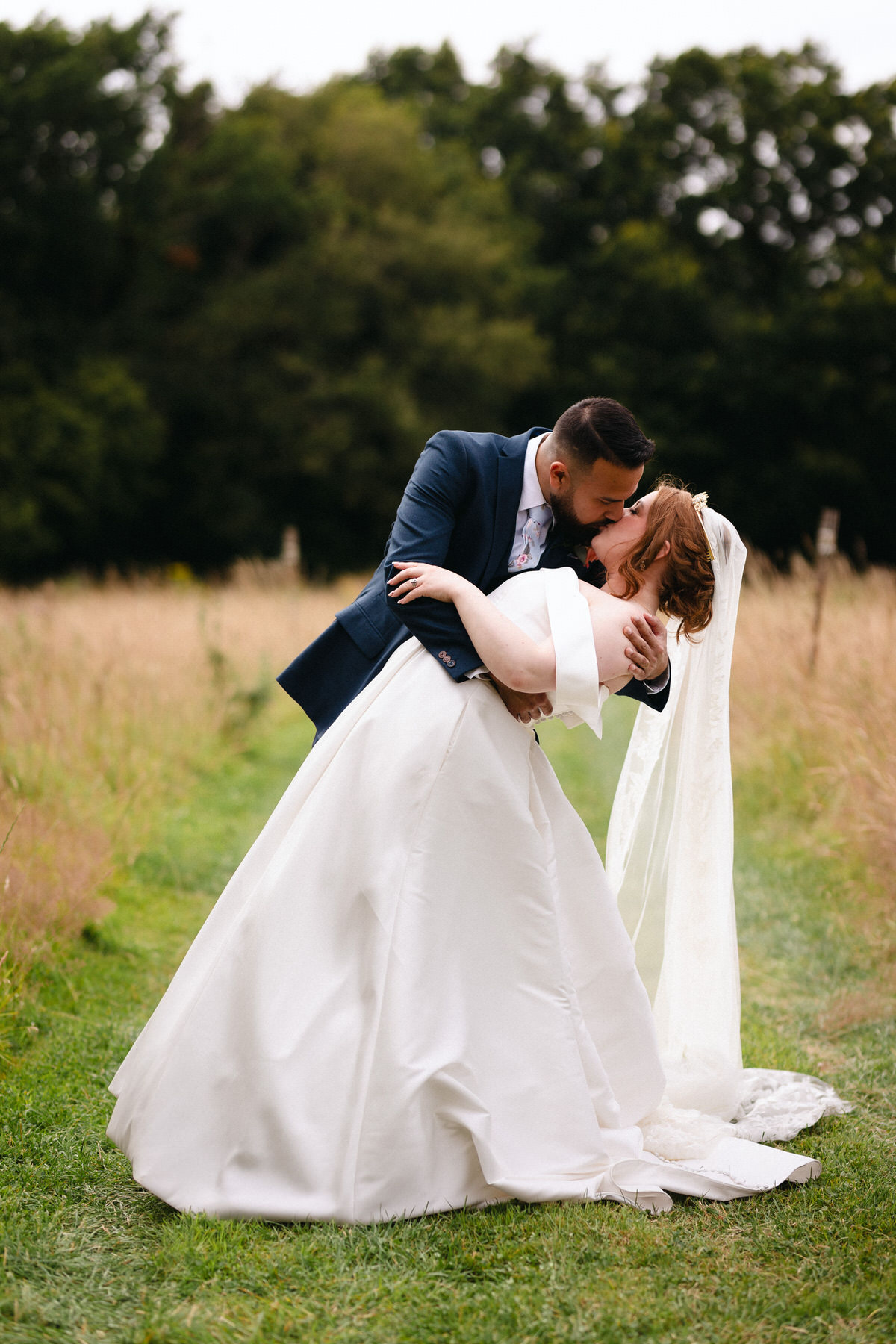 Black and white photo of bride and groom kissing. 