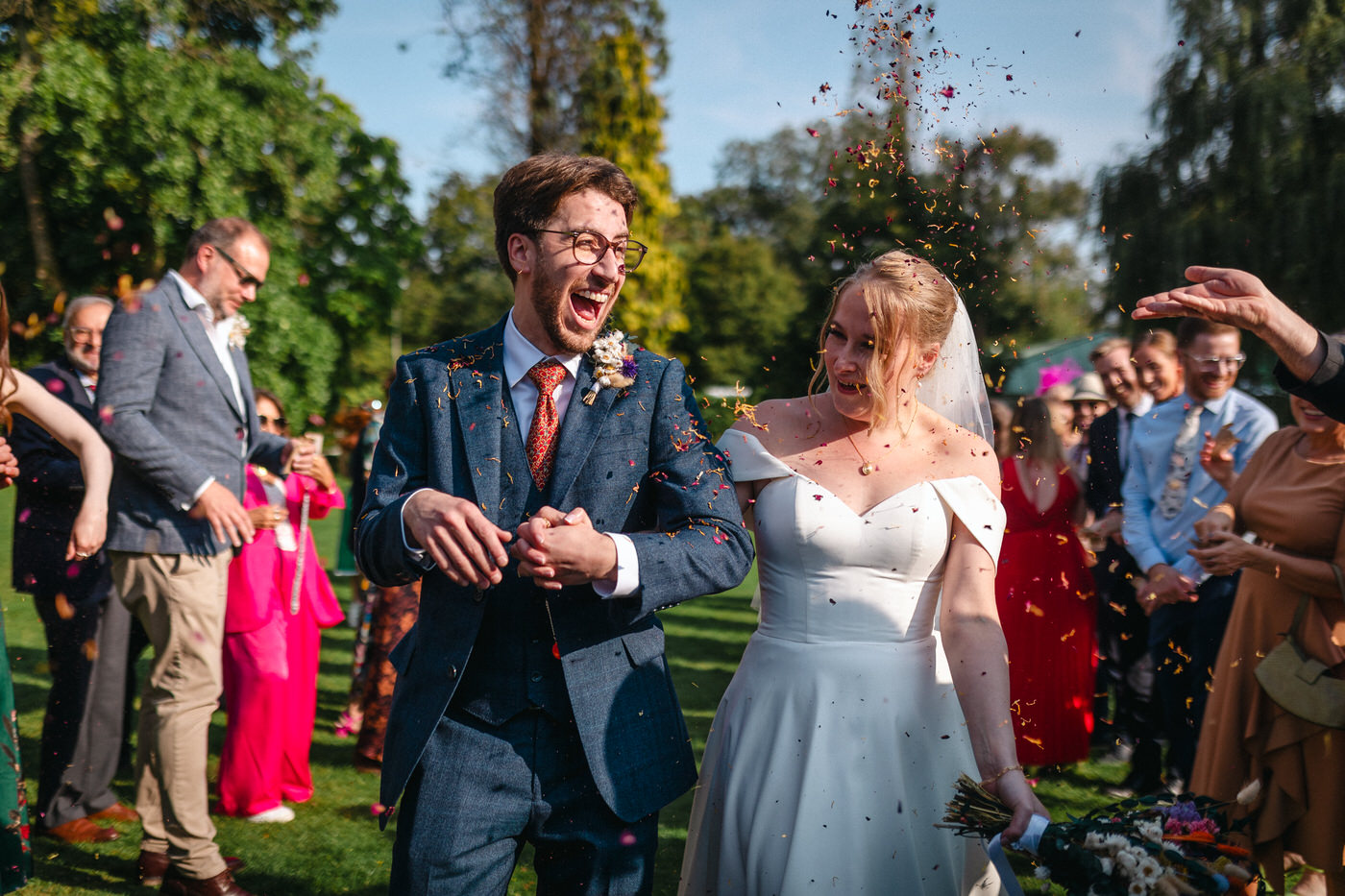 Happy newly wed couple outside Oxford Bodleian Library. Alternative confetti shot.