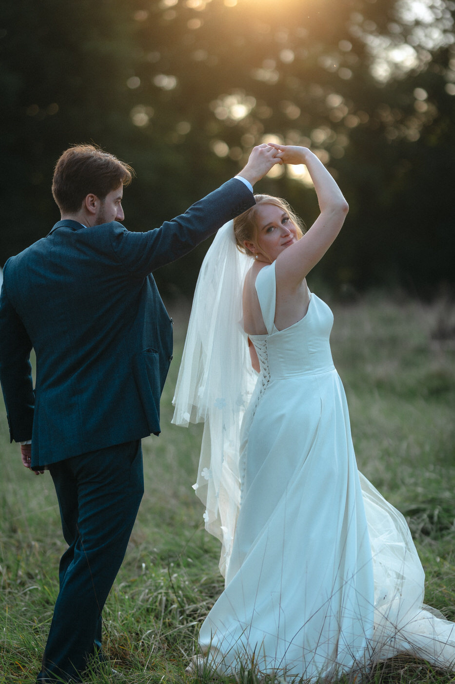 Bride and Groom dancing in a field at sunset golden hour