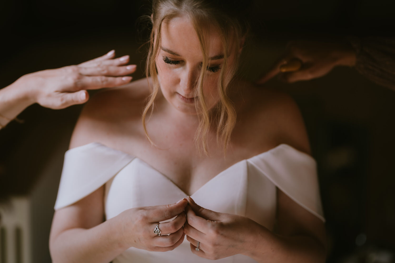 Young Bride drop shoulder dress holding a ring